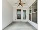 Covered patio with concrete flooring, white siding, ceiling fan, and large windows for outdoor living at 1023 Harvest Park Ln, Suwanee, GA 30024