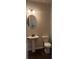 Half bathroom featuring a pedestal sink, oval mirror, and a toilet at 1151 Park Center Cir, Austell, GA 30168