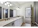Bright bathroom featuring a double vanity, neutral stone countertops, and modern lighting fixtures above a large mirror at 2765 Prado Ln, Marietta, GA 30066