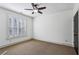 Bedroom with plush carpet, ceiling fan, and large window with white shutters allowing natural light to enter the space at 2765 Prado Ln, Marietta, GA 30066