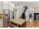 Kitchen view shows a stainless steel refrigerator, kitchen island, wooden floors, and an entry to the living room at 2765 Prado Ln, Marietta, GA 30066