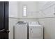 A laundry room featuring a washer, dryer, built-in shelving, a window and beadboard at 2765 Prado Ln, Marietta, GA 30066