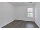 Bedroom featuring hardwood floors, white walls and a window providing natural light at 5090 Leeshire Trce, Tucker, GA 30084