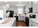 Bright kitchen showcasing gray cabinets, black appliances, quartz countertops, and dark hardwood floors at 6315 Princeton Ridge Dr, Lithonia, GA 30058
