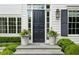 Elegant front entry with classic black door, flanked by potted flowers and sidelights, atop stone steps at 444 Rock Springs Ne Rd, Atlanta, GA 30324