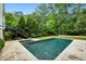 Backyard pool with hot tub surrounded by lush greenery and a stone patio at 444 Rock Springs Ne Rd, Atlanta, GA 30324
