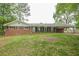 Ranch-style home with a brick exterior, a lawn, and a covered carport on a tree-lined lot at 4935 Golden Sw Cir, Mableton, GA 30126
