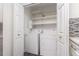 Convenient laundry area featuring modern washer and dryer with shelving at 502 Brighton Pt, Atlanta, GA 30328