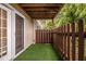 Cozy outdoor patio area with artificial grass, privacy fence, and sliding glass door access at 502 Brighton Pt, Atlanta, GA 30328