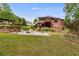 Expansive backyard features a brick home, a patio with seating, and mature landscaping for serene outdoor living at 7511 Biltmore Ln, Douglasville, GA 30135