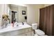 Neutral bathroom features a vanity with white marble countertop and undermount sink with brown shower curtains at 7511 Biltmore Ln, Douglasville, GA 30135