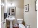 Well-lit half bathroom with pedestal sink and hardwood floors at 7511 Biltmore Ln, Douglasville, GA 30135