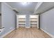 Large bonus room featuring wood-look floors and storage shelves behind white doors at 7511 Biltmore Ln, Douglasville, GA 30135