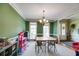 Spacious dining room featuring a chandelier, neutral carpet, and light green paint at 7511 Biltmore Ln, Douglasville, GA 30135