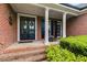 Inviting front porch with rocking chairs and classic brick pillars at 7511 Biltmore Ln, Douglasville, GA 30135