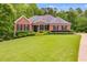 Charming red brick home featuring mature landscaping and a sprawling green lawn at 7511 Biltmore Ln, Douglasville, GA 30135