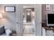 View through doorways of neutral hallway leads to neutral bathroom with matching rugs, and white cabinets at 7511 Biltmore Ln, Douglasville, GA 30135