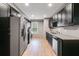 Modern kitchen with stainless steel appliances, dark cabinets, and granite countertops at 7511 Biltmore Ln, Douglasville, GA 30135