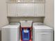 Bright laundry area with updated appliances and overhead cabinet storage at 7511 Biltmore Ln, Douglasville, GA 30135