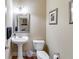 Charming powder room with pedestal sink and decorative mirror, a convenient and stylish space at 7511 Biltmore Ln, Douglasville, GA 30135
