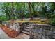 Stone retaining wall in backyard with flower beds and lush green space creating a peaceful outdoor space at 802 Chestnut Nw, Atlanta, GA 30314