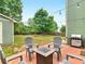 Private backyard featuring patio with fire pit, string lights, and mature trees at 973 Buckhorn Bnd, Locust Grove, GA 30248