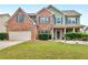 Charming two-story home features a brick facade, manicured lawn, and a welcoming front porch at 973 Buckhorn Bnd, Locust Grove, GA 30248