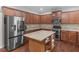 Well-equipped kitchen featuring an island with granite countertop, modern refrigerator, and stainless appliances at 973 Buckhorn Bnd, Locust Grove, GA 30248