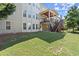 Expansive backyard featuring a covered deck, stairs and lush green lawn, perfect for outdoor enjoyment at 11240 Avery Cove Ct, Alpharetta, GA 30022