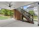 Covered patio with ceiling fan and stairway leading to an upper deck, with a view of the serene backyard at 11240 Avery Cove Ct, Alpharetta, GA 30022