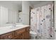 Cozy bathroom with a vanity, toilet and tiled shower with a decorative curtain at 11240 Avery Cove Ct, Alpharetta, GA 30022