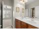 Well-lit bathroom with double sinks, vanity and a view to the bedroom at 11240 Avery Cove Ct, Alpharetta, GA 30022