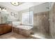 Bright bathroom featuring a large tub, walk-in shower, and unique window at 11240 Avery Cove Ct, Alpharetta, GA 30022