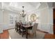 Bright dining room with tray ceilings, chandelier lighting, neutral paint, and large windows at 11240 Avery Cove Ct, Alpharetta, GA 30022