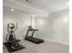 Home gym featuring a treadmill and elliptical machine on carpeted floors with a white door at 11240 Avery Cove Ct, Alpharetta, GA 30022