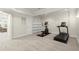 Home gym features a treadmill and elliptical machine on carpeted floors with built-in shelving at 11240 Avery Cove Ct, Alpharetta, GA 30022