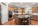 Well-lit kitchen features stainless appliances, granite countertops, ample cabinetry, and an island with seating at 11240 Avery Cove Ct, Alpharetta, GA 30022