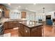 Open kitchen with granite counters, stainless appliances, large island, and seamless flow to the sunroom at 11240 Avery Cove Ct, Alpharetta, GA 30022