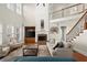 Comfortable living room with fireplace, built-ins, staircase, and hardwood floors at 11240 Avery Cove Ct, Alpharetta, GA 30022