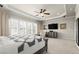 Spacious main bedroom featuring a ceiling fan, sitting area, and television at 11240 Avery Cove Ct, Alpharetta, GA 30022
