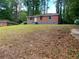 Brick house situated on a grassy lot surrounded by tall trees, offering a serene setting at 2545 Saint Patrick Se St, Atlanta, GA 30317