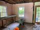 Renovated interior showcasing a pink wall, window, open rafters, and a door leading outside at 2545 Saint Patrick Se St, Atlanta, GA 30317