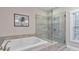 A modern bathroom featuring soaking tub and separate glass shower with a neutral color scheme at 396 Summerhour St, Marietta, GA 30060