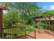 Lush backyard featuring a wooden deck, grassy lawn, mature trees, and beautiful landscaping at 511 Robinson Se Ave, Atlanta, GA 30315