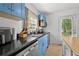 A well-lit kitchen features stainless steel appliances, granite countertops, and blue cabinetry at 511 Robinson Se Ave, Atlanta, GA 30315