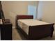 Comfortable bedroom featuring a dark wood bed frame, neutral carpet and decor at 8315 Loch Lomand Ln, Winston, GA 30187