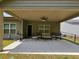 Covered outdoor patio with ceiling fan and ample seating, ideal for relaxing and entertaining in a comfortable setting at 8315 Loch Lomand Ln, Winston, GA 30187