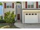 Charming townhome featuring a one-car garage, red shutters and a landscaped front yard at 3504 Benthollow Ln, Duluth, GA 30096