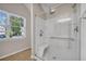 Walk-in shower with clear glass doors, bench, and natural light from a window at 3504 Benthollow Ln, Duluth, GA 30096