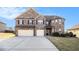 Charming two-story brick home features a two-car garage and manicured lawn on a sunny day at 3621 Guinevere Trce, Douglasville, GA 30135